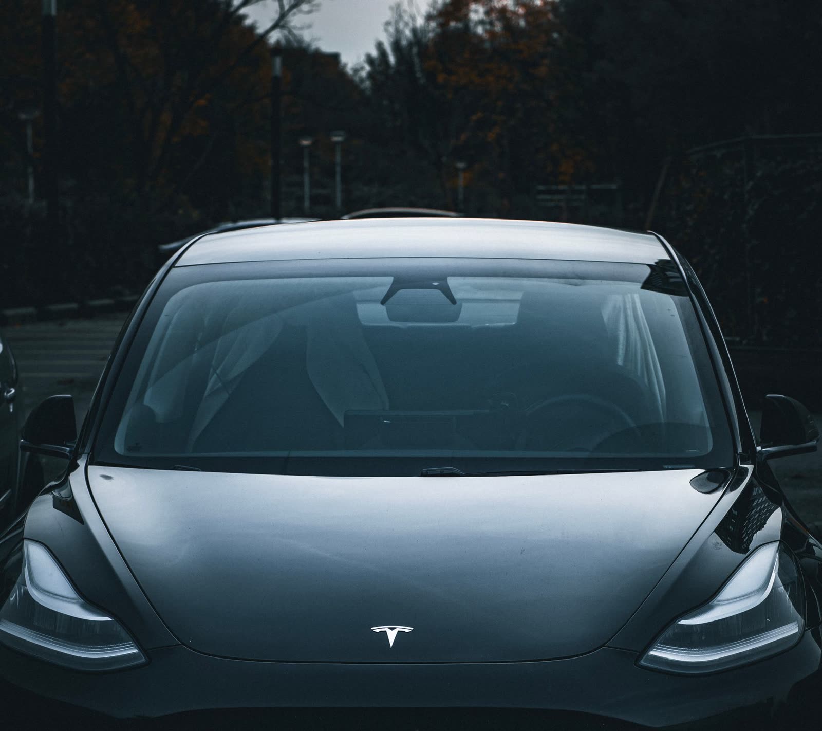 Berline électrique noire, phares allumés